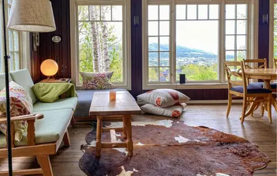 a living room with a couch and a table and windows at 2 Bedroom Lovely Home In Oppdal in Oppdal