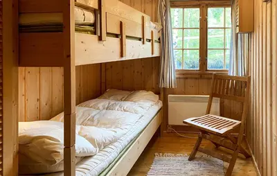 a bedroom with a bunk bed and a chair at 2 Bedroom Lovely Home In Oppdal in Oppdal