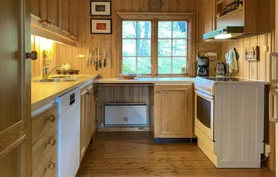 a kitchen with wooden cabinets and a sink and a window at 2 Bedroom Lovely Home In Oppdal in Oppdal