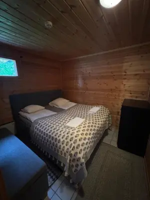 a bedroom with a bed in a wooden cabin at Fjellleilighet med drømmeutsikt in Oppdal
