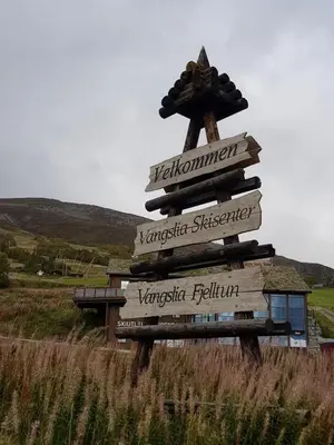 a directional sign in the middle of a field at Fjellleilighet med drømmeutsikt in Oppdal