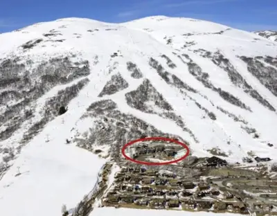 a snow covered mountain with a town in the middle at Fjellleilighet med drømmeutsikt in Oppdal
