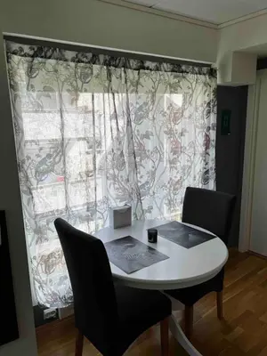 a table and chairs in front of a large window at Staupslia Apartment in Levanger