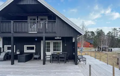 a large black house with a deck and a table at Stunning Home In Bjorli With Wifi in Bjorli
