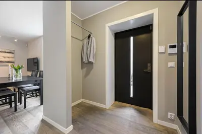 a hallway with a black door and a dining room at Central apartment in Bergen