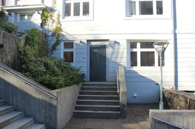 a blue house with stairs leading to a door at Central apartment in Bergen