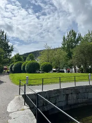 a metal fence next to a stone wall at Sentral leilighet, Bergen in Bergen