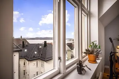 a window with a view of a city at Bright Top-Floor Apartment with Sea View in Bergen
