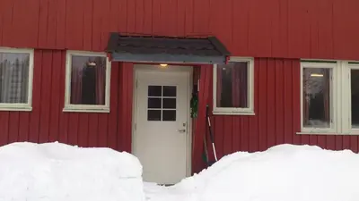 a red house with a white door in the snow at Feriested i Tørberget in Tørberget