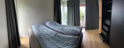 a bed sitting in a room with a window at Husafjellet in Ålesund