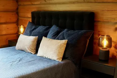 a bedroom with a bed with two pillows and two lights at Exclusive Fjord Lodge with Private Jacuzzi and Epic Views in Lii