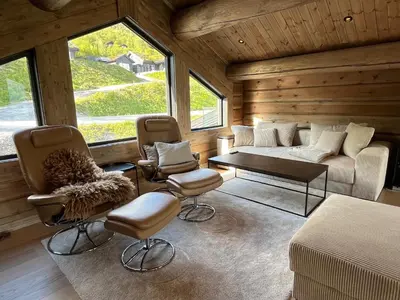 a living room with a couch and chairs and a table at Exclusive Fjord Lodge with Private Jacuzzi and Epic Views in Lii