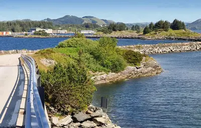 a bridge over a body of water with trees at Nice Home In Manger With House Sea View in Manger