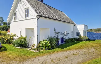 a white house with the water in the background at Nice Home In Manger With House Sea View in Manger