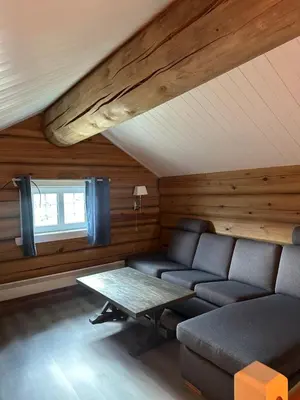 a living room with a couch and a table at Lekker tømmerhytte in Tyinkrysset
