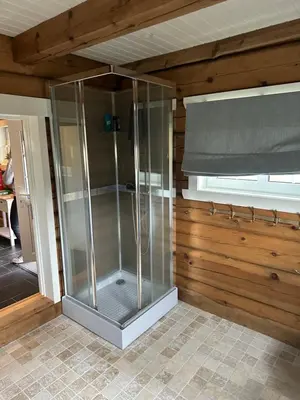 a glass shower in a room with a window at Lekker tømmerhytte in Tyinkrysset