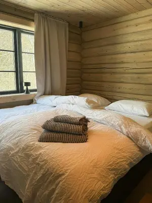 a large bed in a room with a wooden wall at Timber Cabin By The Ski Slopes In Oppdal in Oppdal