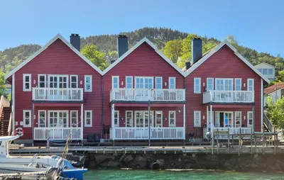 a large red house on a dock with a marina at Nice Apartment In Auklandshamn in Vestvik