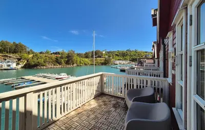 a balcony with chairs and a view of a river at Nice Apartment In Auklandshamn in Vestvik