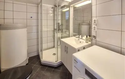 a white bathroom with a shower and a sink at Nice Apartment In Auklandshamn in Vestvik