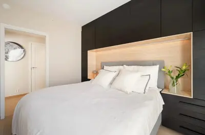 a bedroom with a large white bed with a black headboard at Wow in Bergen