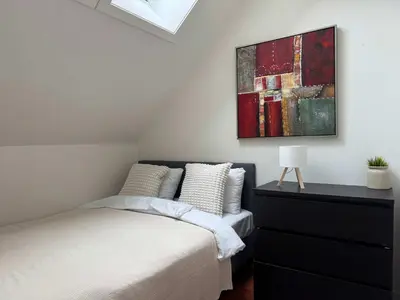 a bedroom with a bed and a painting on the wall at Heimby Homes - Four Bedroom Family Penthouse in Bergen