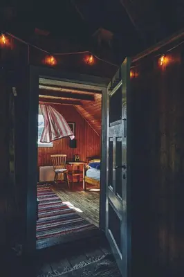 an open door to a room with a bed and a table at Historic Farmhouse In Scenic Isfjorden in Isfjorden