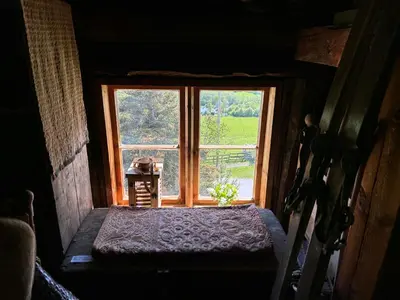 an open window in a room with a table and a chair at Historic Farmhouse In Scenic Isfjorden in Isfjorden