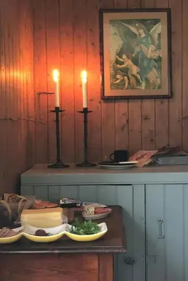 a table with two candles and a plate of food at Historic Farmhouse In Scenic Isfjorden in Isfjorden