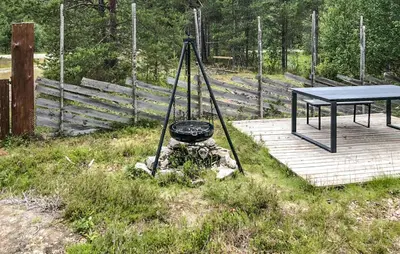 a picnic table and a grill on a wooden deck at 4 Bedroom Stunning Home In Tynset in Tynset