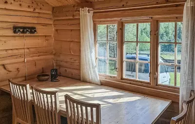 a dining room with a wooden table and a window at 4 Bedroom Stunning Home In Tynset in Tynset