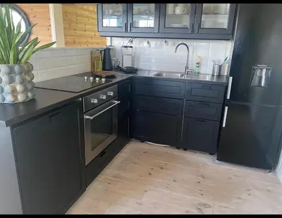 a kitchen with black cabinets and a sink at Ingeborgstova in Lii