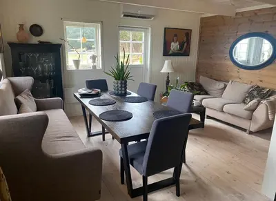 a living room with a table and chairs at Ingeborgstova in Lii
