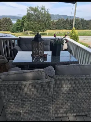 a patio with a table and chairs on a deck at Ingeborgstova in Lii