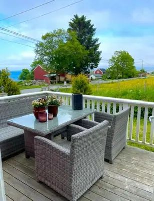 a patio with a table and chairs on a deck at Ingeborgstova in Lii
