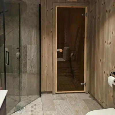a bathroom with a shower and a glass door at Mountain Cabin With Sauna In Sunnmørsalpane in Brunstad