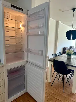 a refrigerator with its door open with a table and chairs at Fjordpust og fjellsteg - Stryn in Stryn