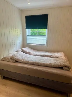 a bed in a room with a window at Fjordpust og fjellsteg - Stryn in Stryn