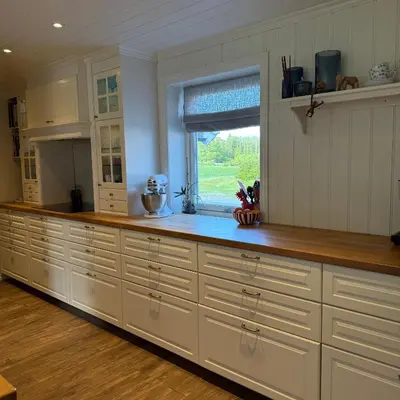 a large kitchen with white cabinets and a window at 047 Farmhouse - Nevlunghavn in Lii