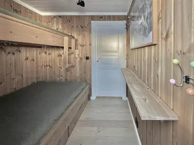 a wooden room with a bed and a door at Modern Family Cabin By The Ski Lift in Flå