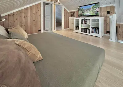a bedroom with a bed and a flat screen tv at Modern Family Cabin By The Ski Lift in Flå