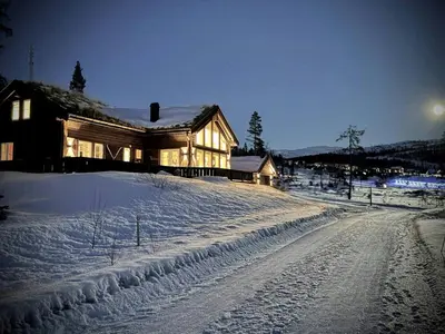 a house on a snow covered road in front of a house at Modern Family Cabin By The Ski Lift in Flå