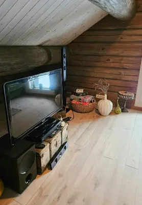a living room with a flat screen tv in a attic at Timber Cabin With Mountain Views In Synnfjellet in Skartlia