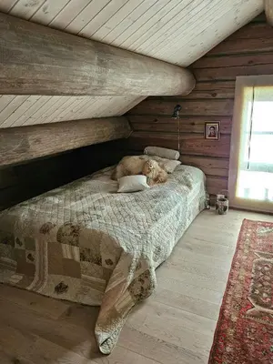a large bed in a room with wooden walls at Timber Cabin With Mountain Views In Synnfjellet in Skartlia