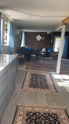 a kitchen and living room with a rug on the floor at Scandinavian Style Ridabu Hamar in Hamar