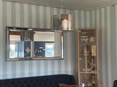 a mirror in a room with a couch and a shelf at Scandinavian Style Ridabu Hamar in Hamar