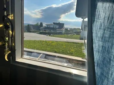 a window with a view of a field and a house at Scandinavian Style Ridabu Hamar in Hamar