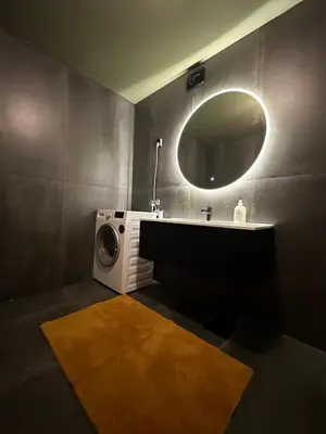 a bathroom with a sink and a washing machine at Leilighet nært sentrum in Stryn