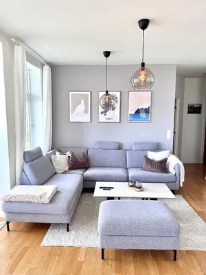 a living room with a blue couch and a table at Stor 3-roms leilighet med utsikt in Trondheim