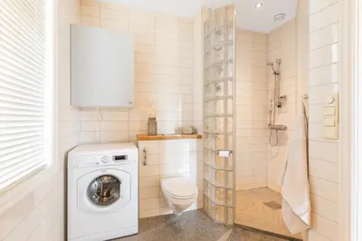 a bathroom with a washing machine and a toilet at Stor 3-roms leilighet med utsikt in Trondheim